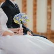 unrecognizable young newlyweds sitting together during wedding celebration