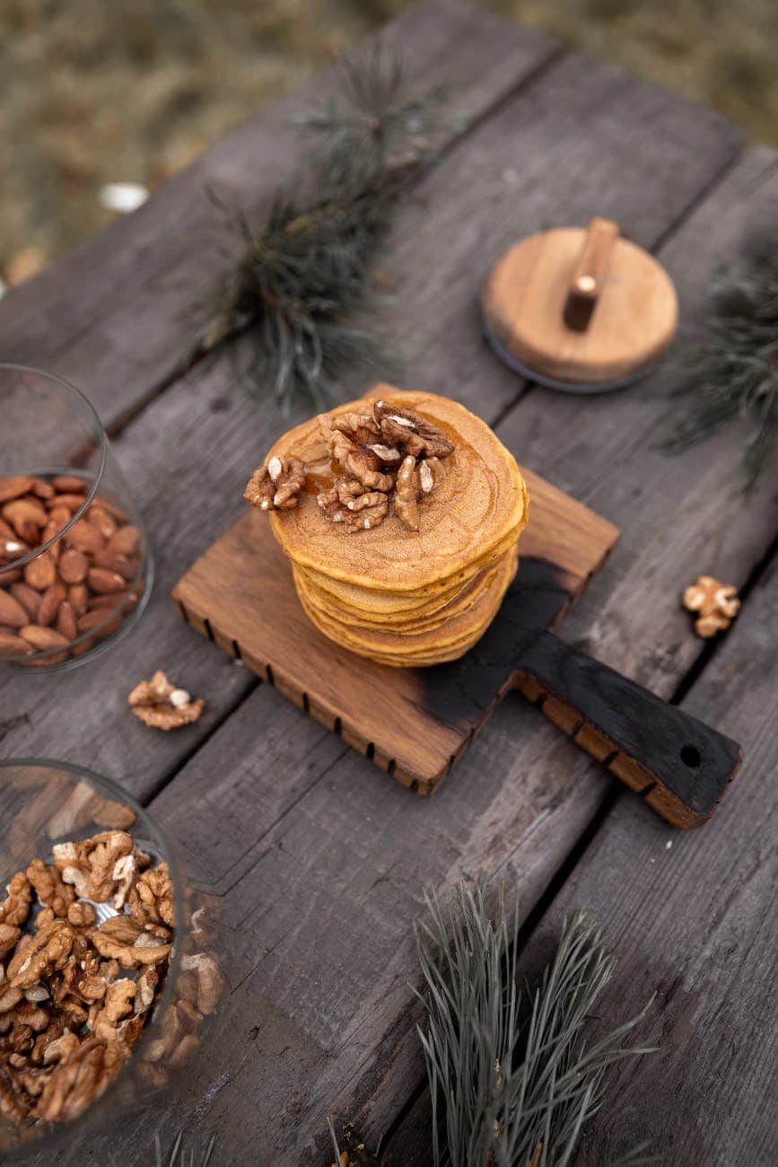 brown wooden chopping board with stack of pancakes