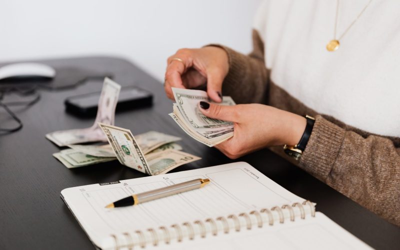 crop payroll clerk counting money while sitting at table