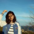 woman on mountain taking picture while raising her hand on her head