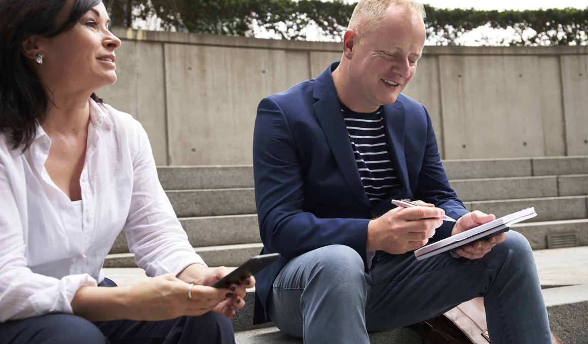 woman and man having a discussion while sitting on steps