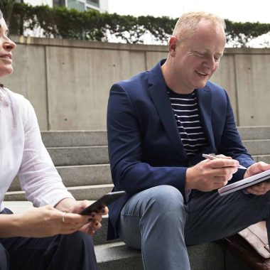 woman and man having a discussion while sitting on steps