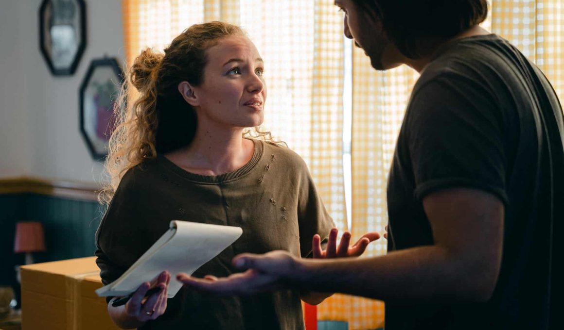 worried couple with notebook looking at each other