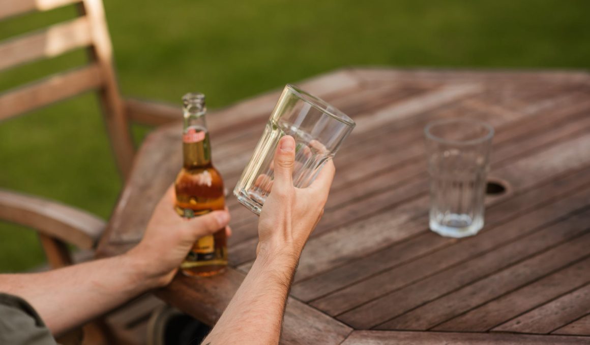 man with glass and beer bottle