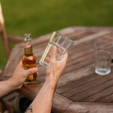 man with glass and beer bottle