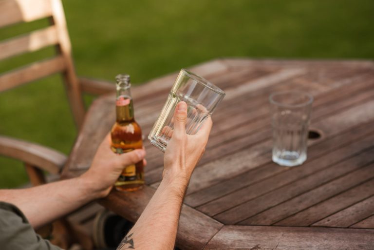 man with glass and beer bottle