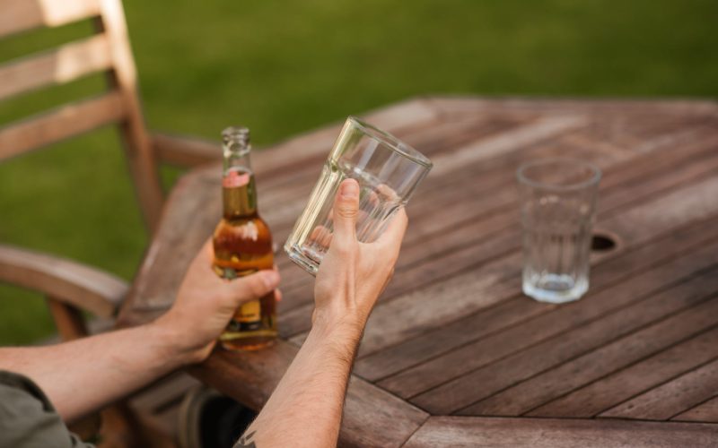 man with glass and beer bottle