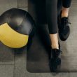 person standing on a mat beside a ball