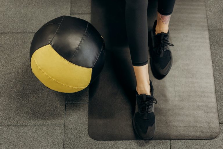 person standing on a mat beside a ball