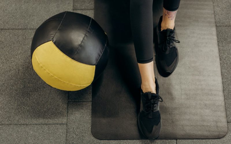 person standing on a mat beside a ball