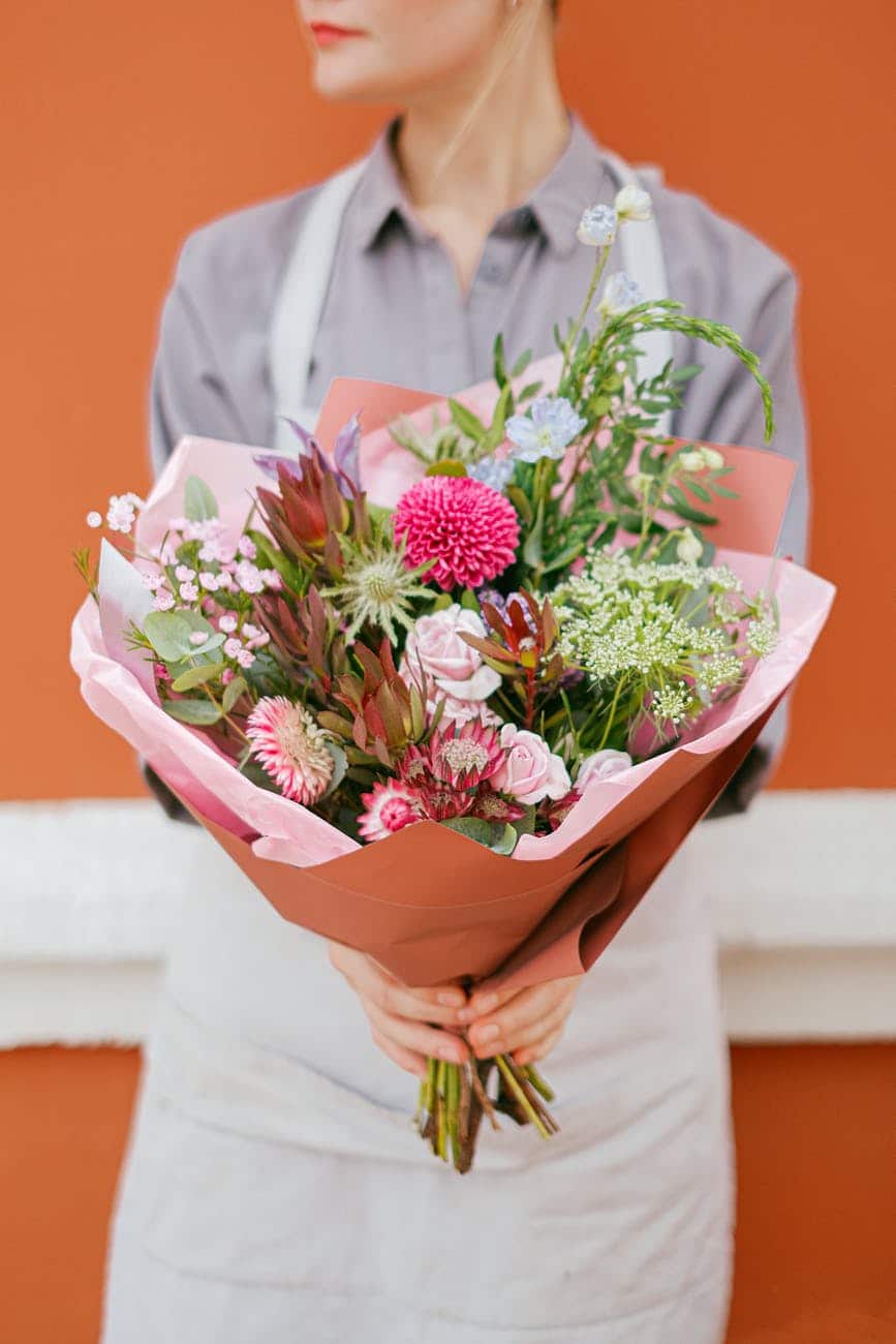 crop woman with bouquet of flowers