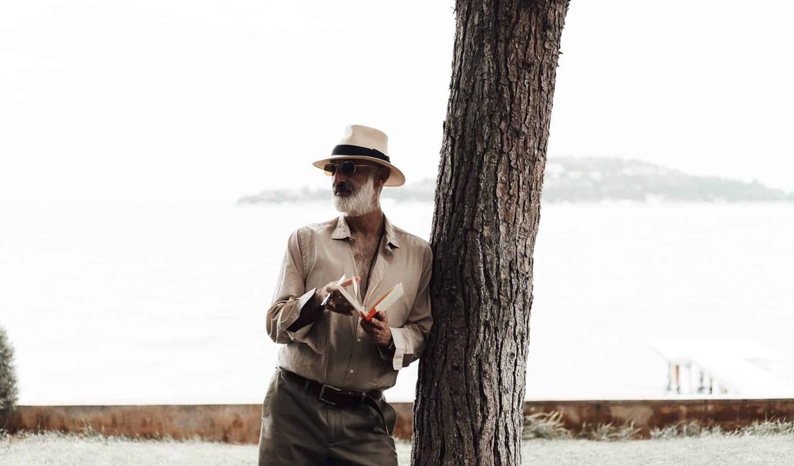 stylish mature man reading book on waterfront