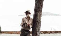 stylish mature man reading book on waterfront