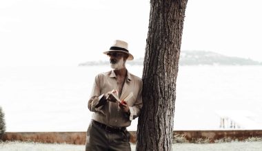 stylish mature man reading book on waterfront