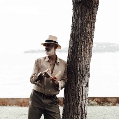 stylish mature man reading book on waterfront