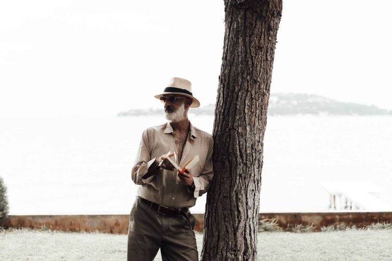 stylish mature man reading book on waterfront