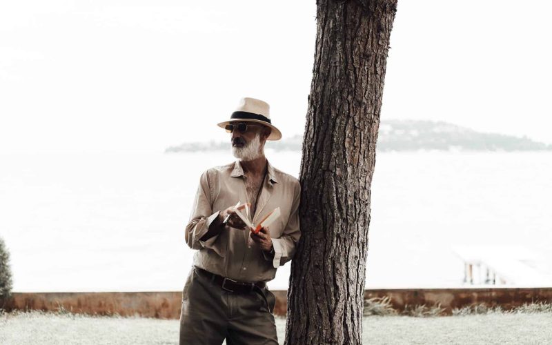 stylish mature man reading book on waterfront