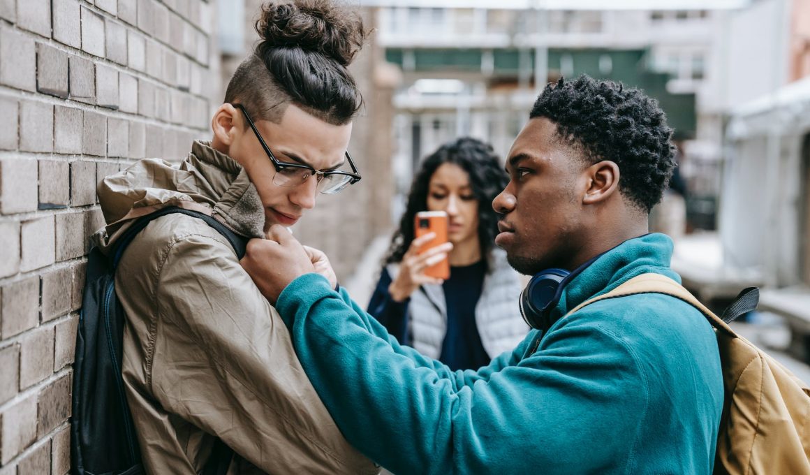 multiracial students having argument on city street