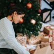 ethnic woman with pile of present boxes against christmas tree