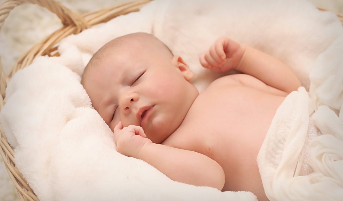 baby sleeping on white cotton