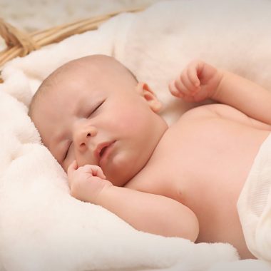 baby sleeping on white cotton