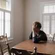 photo of man leaning on wooden table