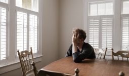 photo of man leaning on wooden table