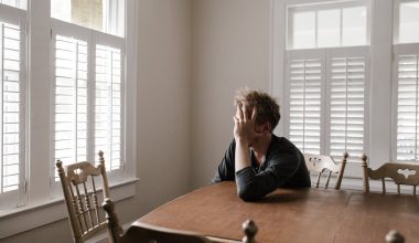 photo of man leaning on wooden table