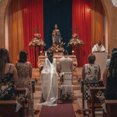 unrecognizable newlyweds and guests standing in church hall