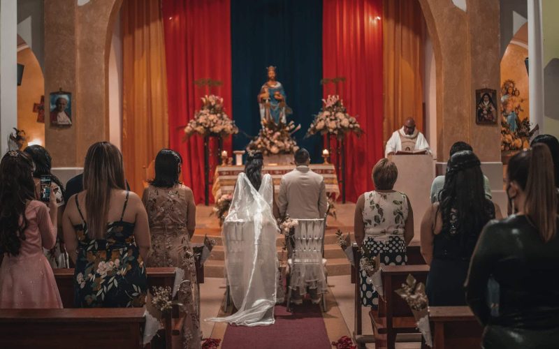 unrecognizable newlyweds and guests standing in church hall