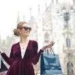 woman wearing maroon velvet plunge neck long sleeved dress while carrying several paper bags photography