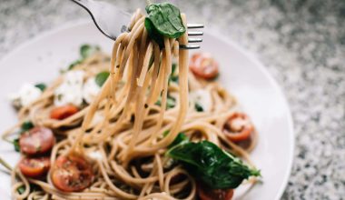 selective focus photography of pasta with tomato and basil