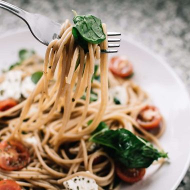 selective focus photography of pasta with tomato and basil