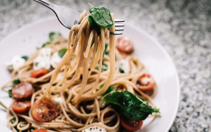 selective focus photography of pasta with tomato and basil