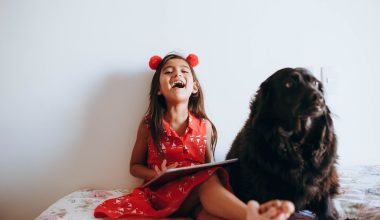 happy girl sitting beside black dog