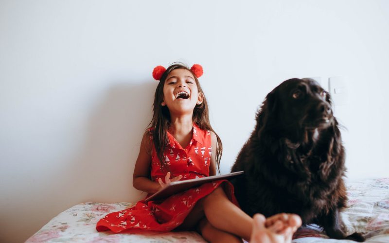 happy girl sitting beside black dog