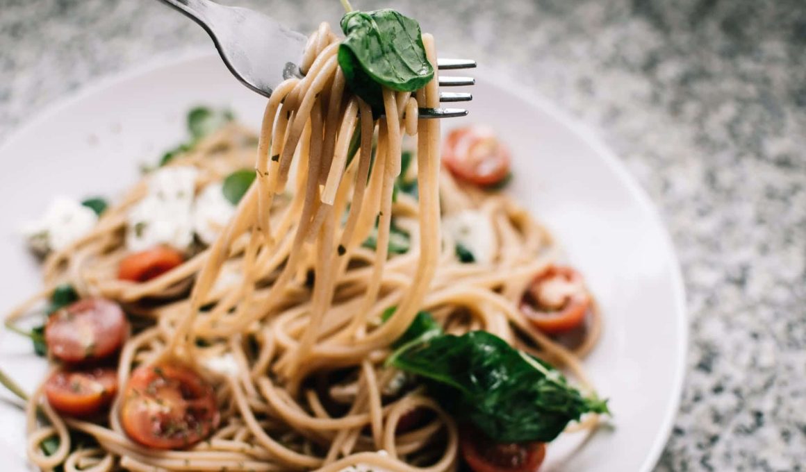 selective focus photography of pasta with tomato and basil